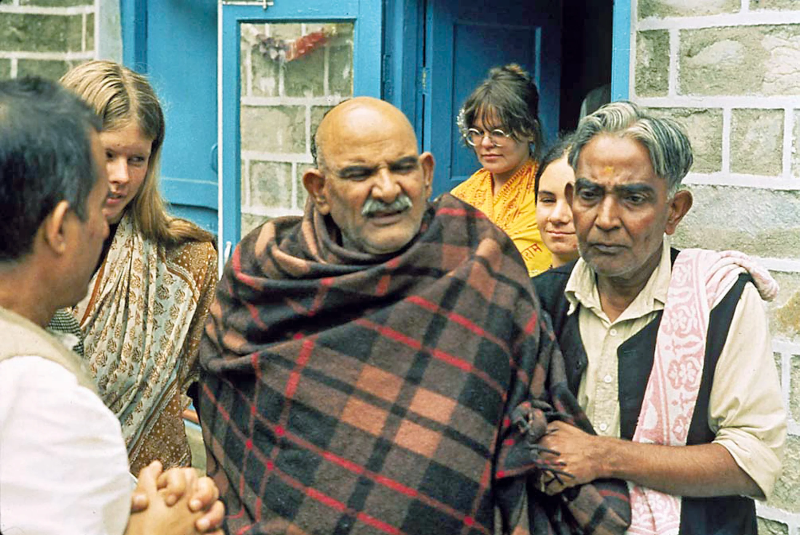 Sri Neem Karoli Baba mit Dada Mukherjee, hinter Baba in der Tür zu Seinem 