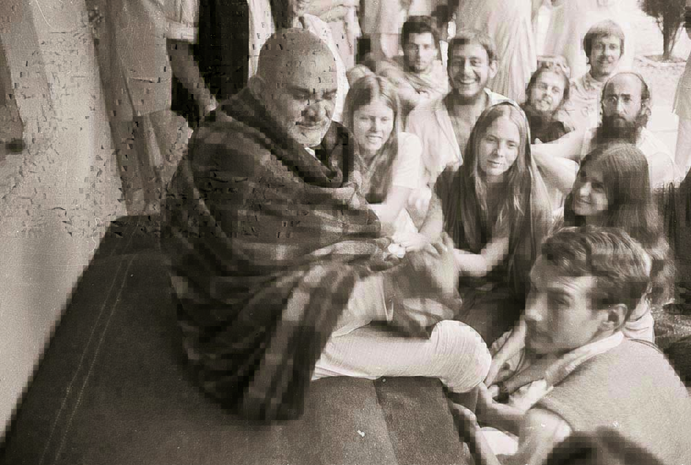 Baba im Ashram Kainchi, sitzt auf dem Thakat und ist umgeben von Seinen Devotees - Vishnu Digambar, Ma’s spiritueller Weggefährte, lachend (in weißer Kleidung in der Bildmitte)