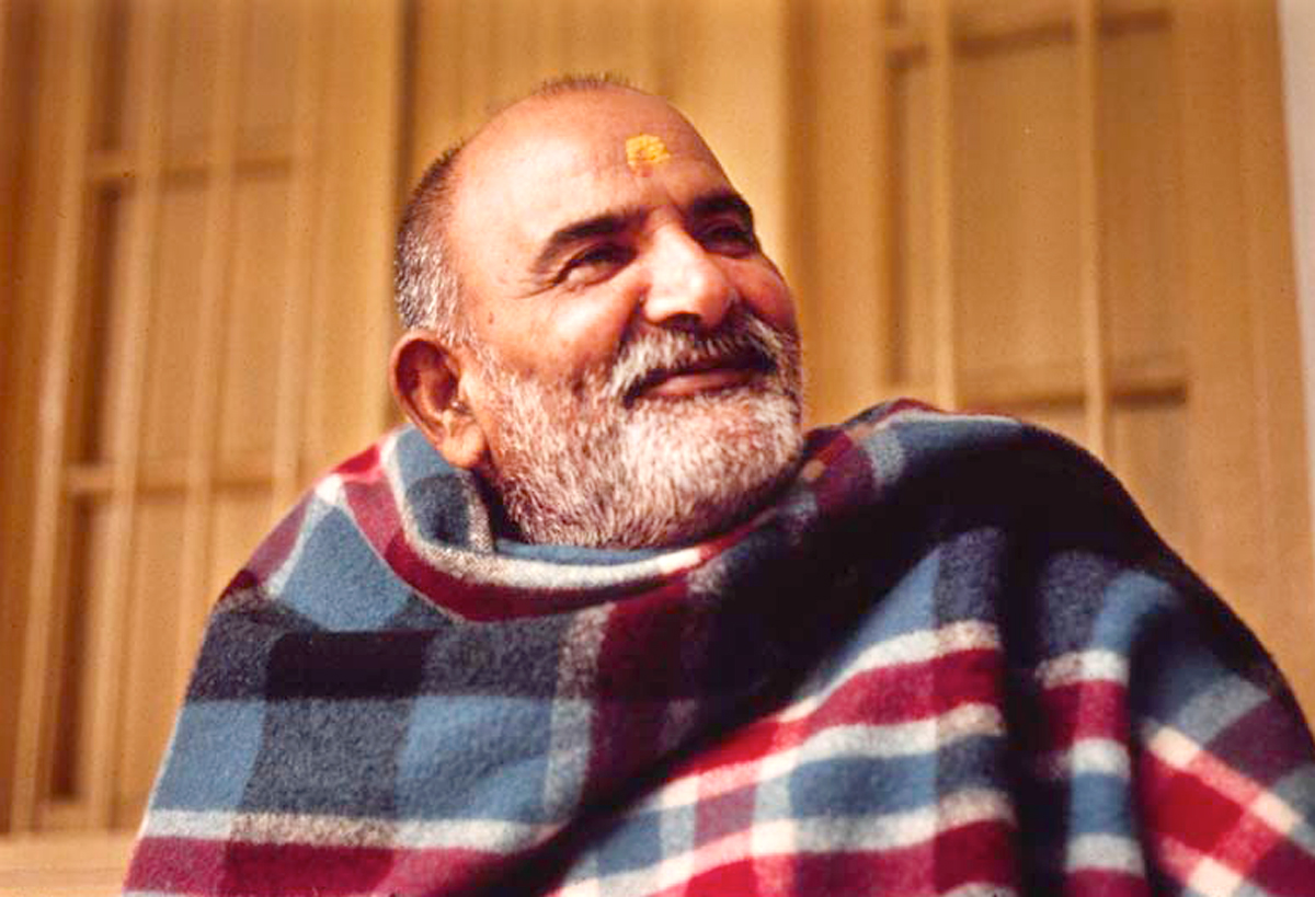 Baba in eine bunte Decke gehüllt in Seinem Ashram in Vrindavan, Indien