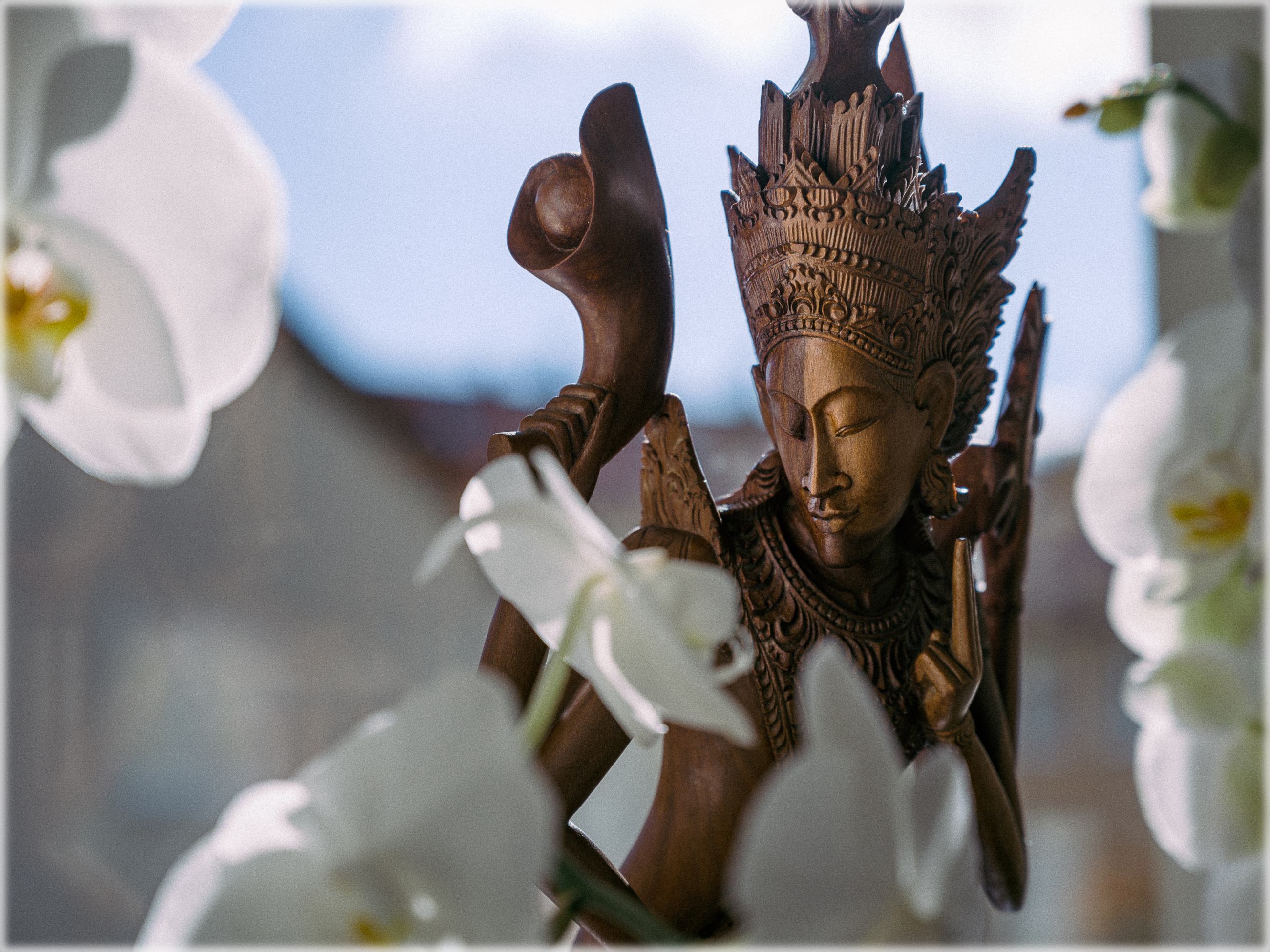 Statue von Vishnu mit Blüten im Vordergrund