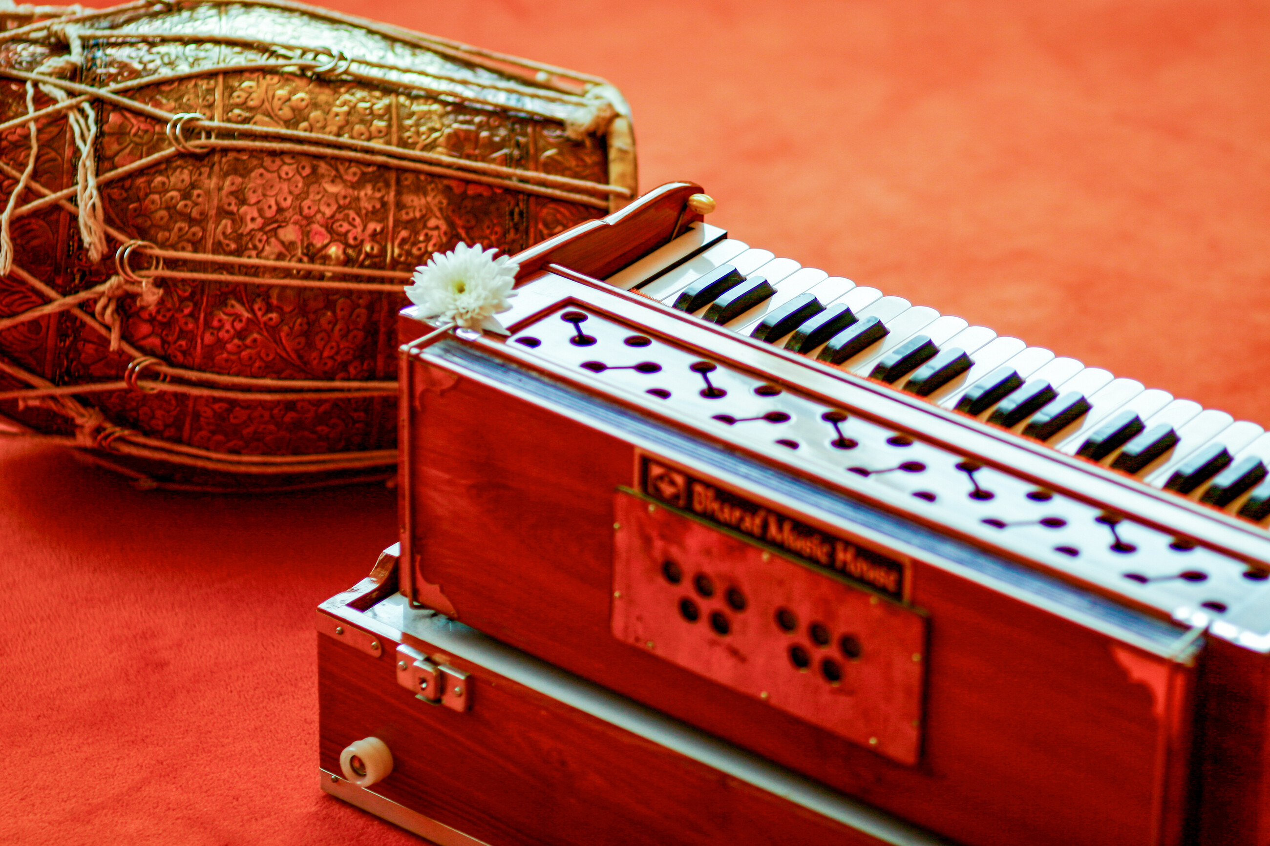 Ein Harmonium mit einer Bl&uuml;te geschm&uuml;ckt und eine Dolak &ndash; eine nordindische Trommel &ndash; in der Kirtan-Halle des Ashram